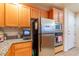 Bright kitchen with stainless steel fridge, microwave, and oven; complemented by warm wood cabinets at 19 E Agate Ave # 307, Las Vegas, NV 89123