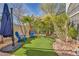 Landscaped backyard with artificial grass, desert landscaping, and outdoor seating area at 2107 Eaglepath Cir, Henderson, NV 89074