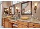 Bathroom with dual sinks, granite countertops, and decorative mirrors and sconces at 2107 Eaglepath Cir, Henderson, NV 89074