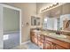 Bathroom featuring double sinks, granite countertops, wood cabinets, and neutral color palette at 2107 Eaglepath Cir, Henderson, NV 89074