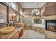 Elegant bathroom featuring dual sinks, a glass shower, a soaking tub and a stone fireplace at 2107 Eaglepath Cir, Henderson, NV 89074