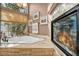 Bathroom featuring a soaking tub with marble surround next to a see-through fireplace and large windows at 2107 Eaglepath Cir, Henderson, NV 89074