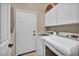 Well-equipped laundry room with white cabinets and modern washer and dryer at 2107 Eaglepath Cir, Henderson, NV 89074