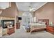 Cozy main bedroom featuring a fireplace, ceiling fan, and a large window at 2107 Eaglepath Cir, Henderson, NV 89074