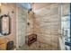 Elegant travertine tile shower with glass enclosure and seating bench at 2107 Eaglepath Cir, Henderson, NV 89074