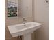 Powder room featuring a pedestal sink with modern faucet and decorative mirror at 221 Errogie St, Henderson, NV 89012