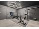 Home garage transformation into gym; featuring stationary bike, weights, and a motivational 'No Excuses' mirror at 221 Errogie St, Henderson, NV 89012