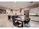 A modern kitchen with stainless steel appliances, white cabinets and a dark island with bar seating at 221 Errogie St, Henderson, NV 89012