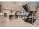 Bright open-concept living area with a modern staircase, sleek kitchen, and a comfortable seating area at 221 Errogie St, Henderson, NV 89012