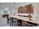 Elegant bar area with custom cabinets, seating, wine storage, and a marble countertop at 2239 Discovery Lake Ct, Henderson, NV 89044