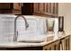 Elegant bar area showcasing a white marble countertop, a stainless steel sink, and tiled backsplash at 2239 Discovery Lake Ct, Henderson, NV 89044