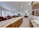 Open-concept floorplan features bar area with marble counters, wine fridge, sink, and custom cabinets at 2239 Discovery Lake Ct, Henderson, NV 89044