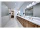 Bathroom with double sinks, a walk-in shower, and a large mirror with vanity lighting at 2239 Discovery Lake Ct, Henderson, NV 89044