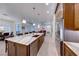 Kitchen with large island open to dining and living space with stainless steel appliances and dark wood cabinetry at 2239 Discovery Lake Ct, Henderson, NV 89044