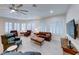 Bright living room featuring a ceiling fan, plantation shutters and a large brown leather sofa and chairs at 2239 Discovery Lake Ct, Henderson, NV 89044