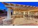 Outdoor kitchen with built-in barbecue, bar seating, pergola, and travertine tile at 2239 Discovery Lake Ct, Henderson, NV 89044