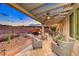 Inviting outdoor seating area with patio furniture, fire pit, pergola, travertine tile and desert landscaping at 2239 Discovery Lake Ct, Henderson, NV 89044