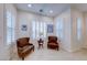 Cozy sitting area with two leather chairs, a small table, and natural light from the window at 2239 Discovery Lake Ct, Henderson, NV 89044