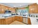 Well-lit kitchen with stainless steel appliances, wood cabinets, and eat-in counter at 2728 Monrovia Dr, Las Vegas, NV 89117