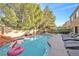 Spacious backyard with a large pool, outdoor seating, and lush landscaping at 2728 Monrovia Dr, Las Vegas, NV 89117