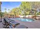 Relaxing backyard pool area with lounge chairs, mature trees, and a rock waterfall at 2728 Monrovia Dr, Las Vegas, NV 89117