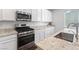 Bright kitchen featuring granite countertops, a stainless steel gas range and white cabinetry at 2740 Aldine Ct, Las Vegas, NV 89142