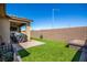 A backyard featuring a covered patio with outdoor seating and artificial turf at 306 Dedication Ave, Henderson, NV 89011