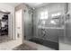 Luxurious bathroom includes a glass-enclosed shower, soaking tub, and elegant tile work, with a view to closet at 306 Dedication Ave, Henderson, NV 89011