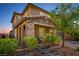 Inviting two-story home with a stone porch, brick driveway, lush landscaping, and manicured lawn at 306 Dedication Ave, Henderson, NV 89011