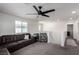 This living room features plush carpeting, a modern ceiling fan, and comfortable brown leather furniture at 306 Dedication Ave, Henderson, NV 89011