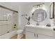 Modern bathroom with a glass shower door, round mirror, and elegant white vanity at 3318 N Decatur Blvd # 2007, Las Vegas, NV 89130