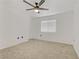 A bright, empty bedroom features neutral carpet, white walls, a ceiling fan and a window at 3318 N Decatur Blvd # 2007, Las Vegas, NV 89130