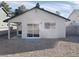 Back exterior with sliding glass door and gravel yard at 4240 Caliper Dr, Las Vegas, NV 89110