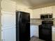 Kitchen featuring white cabinets, black appliances and view out window at 4240 Caliper Dr, Las Vegas, NV 89110