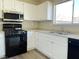 Kitchen featuring white cabinets, black appliances, stainless steel sink and window at 4240 Caliper Dr, Las Vegas, NV 89110