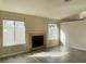 Inviting living room featuring a fireplace, light wood floors, and multiple windows for ample natural light at 4240 Caliper Dr, Las Vegas, NV 89110