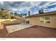 Spacious backyard with rock landscaping, partial patio, privacy wall, and view of city buildings in distance at 4522 Via San Rafael, Las Vegas, NV 89103