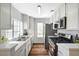 Modern kitchen with white cabinetry, stainless steel appliances, and wood-look flooring at 4827 S Torrey Pines Dr # 204, Las Vegas, NV 89103