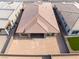 An aerial view showcases a modern home with a terracotta-colored roof, surrounded by a large, flat, empty lot at 5015 Terramont Dr, Las Vegas, NV 89135