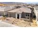 A modern single-story home with a two-car garage, a stone entranceway, brick paver driveway, and desert landscaping at 5015 Terramont Dr, Las Vegas, NV 89135