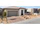 A charming single-story home features a two-car garage, stone accents, desert landscaping, and a brick paver driveway at 5015 Terramont Dr, Las Vegas, NV 89135