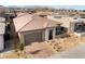 An elevated view of a modern home with desert landscaping, a brick paver driveway, and a two-car garage at 5015 Terramont Dr, Las Vegas, NV 89135