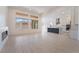 Open-concept living room featuring large windows, a modern fireplace, and seamless flow into the kitchen at 5015 Terramont Dr, Las Vegas, NV 89135