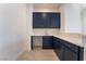 Stylish wet bar featuring navy cabinets, marble countertop, and tiled floors at 5015 Terramont Dr, Las Vegas, NV 89135