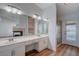 Bathroom featuring double sinks, white cabinets, large mirror, and a glass shower at 519 Cayuga Ct, Boulder City, NV 89005