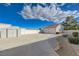 Wide driveway leads to garage and shed, surrounded by xeriscaped yard and a clear blue sky at 519 Cayuga Ct, Boulder City, NV 89005