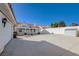 White exterior showcasing a lengthy covered patio with a spacious driveway and lush landscaping at 519 Cayuga Ct, Boulder City, NV 89005