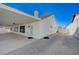 Home exterior featuring a long, covered patio with a spacious driveway and white fencing at 519 Cayuga Ct, Boulder City, NV 89005