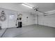 Clean, empty garage with freshly painted floor, white walls, door to outside, storage shelves and an opener at 519 Cayuga Ct, Boulder City, NV 89005