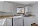 Well-lit laundry room with washer, dryer, sink, and storage at 519 Cayuga Ct, Boulder City, NV 89005